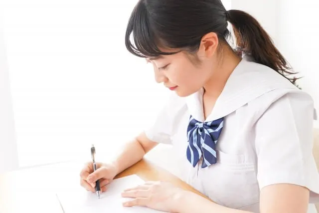 試験に集中して解答する女子学生