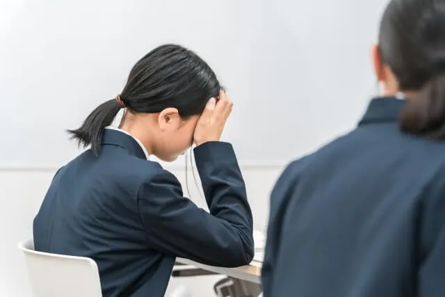 頭を抱えるスーツ姿の学生