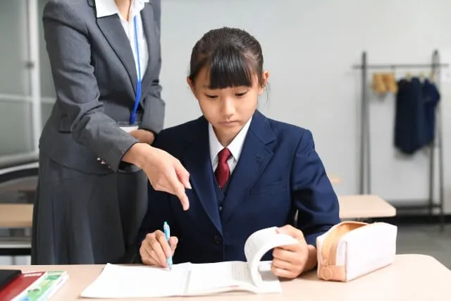 教師が指導するスーツ姿の生徒